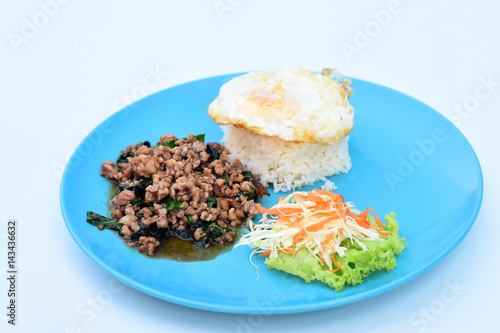 Rice topped with fried egg  stir-fried pork and basil