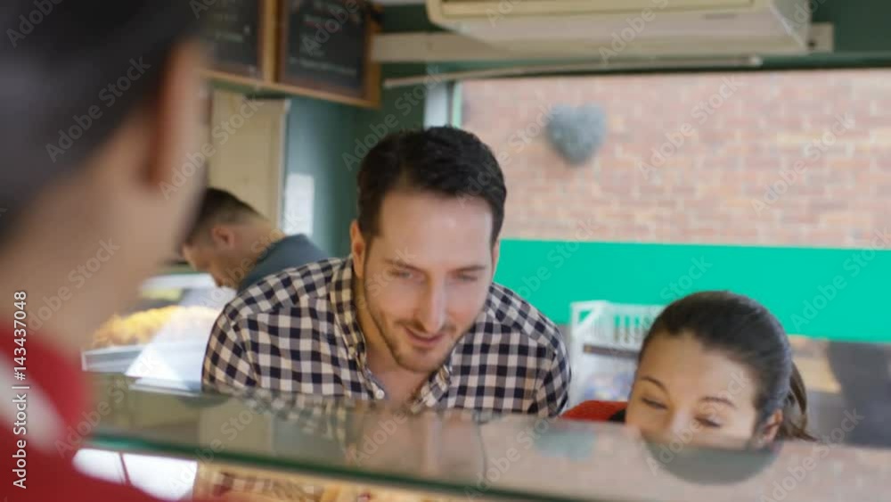 Couple in a bakery shop making contactless payment by cell phone Couple in a bakery shop making contactless payment by cell phone
