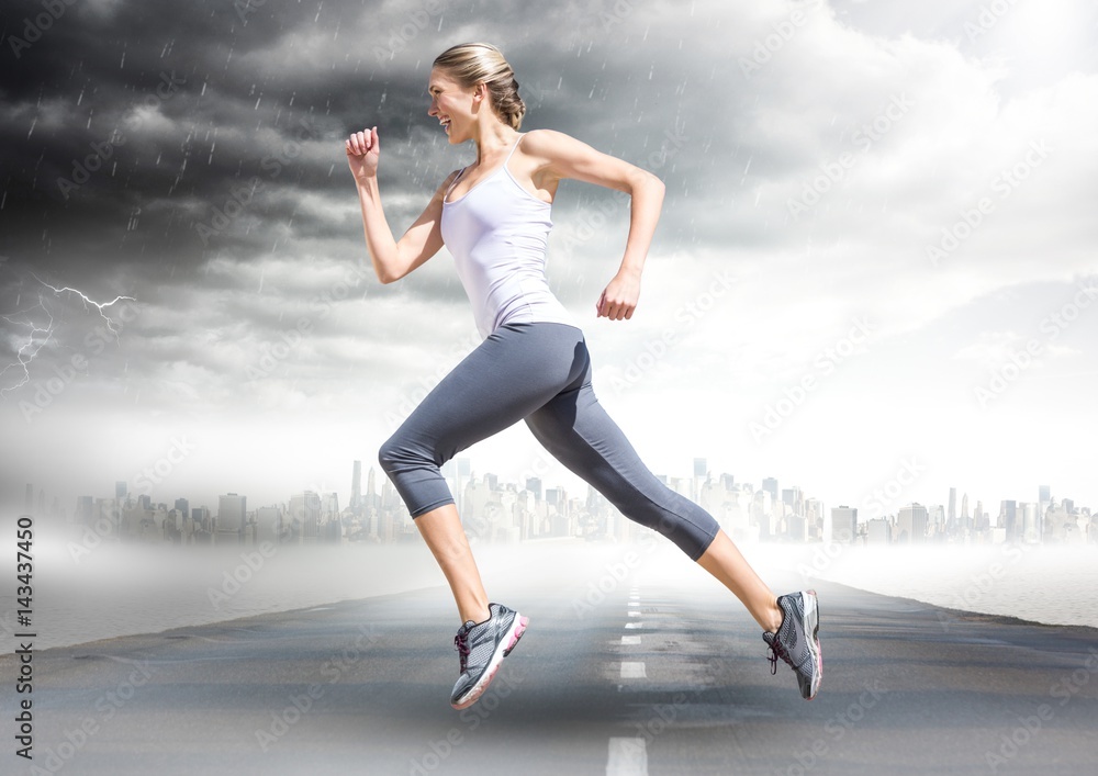 Female runner going across road with skyline and storm Female runner going across road with skyline and storm