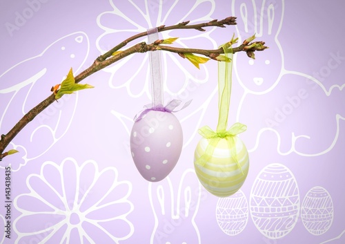 Easter eggs hanging on branch in front of pattern