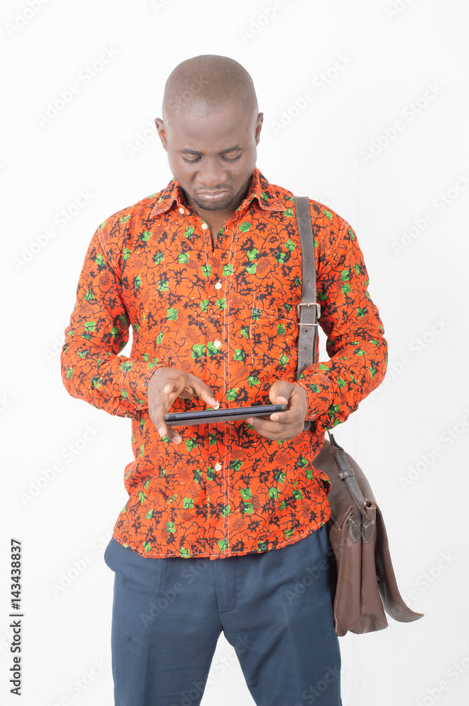 jeune homme africain debout avec un sac et utilisant une tablette Stock  Photo | Adobe Stock