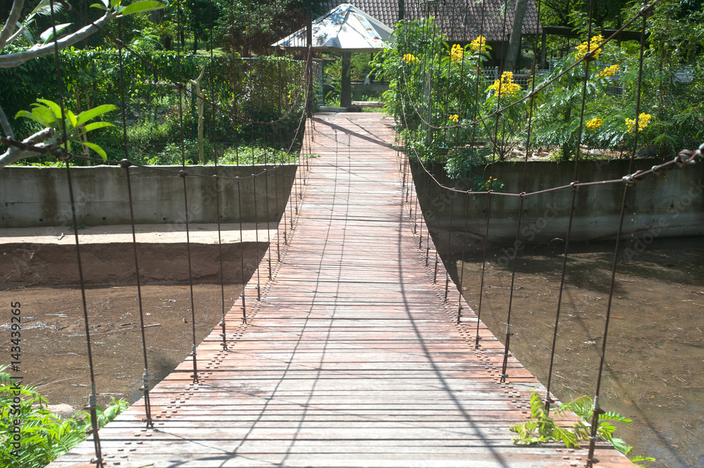 Obraz premium Wire hanging bridge with wooden pathway in Thailand.