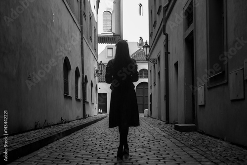 Young woman in old europian city in black and white colors