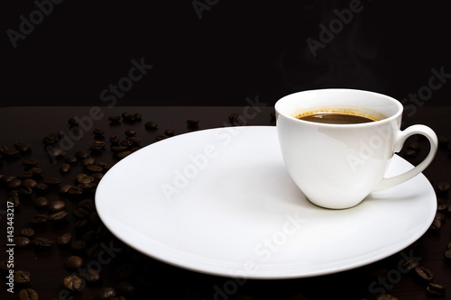 warm cup of coffee on brown background with many coffee beans around