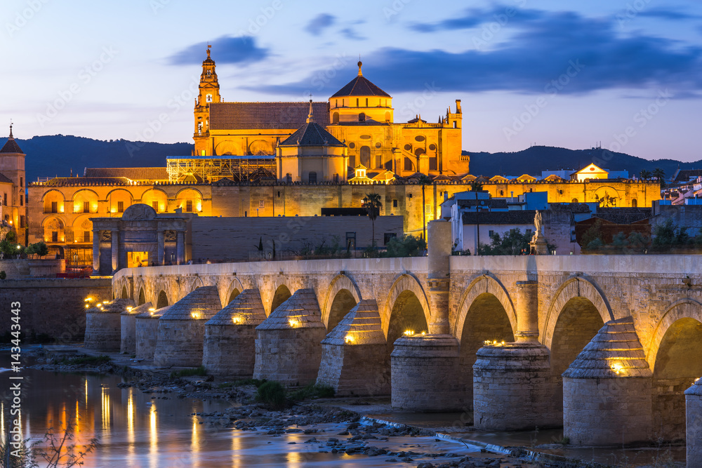 Illuminated Roman Bridge and Mosque-Cathedral at twilight in Cordoba, Spain