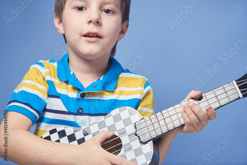 European boy playing ukulele.