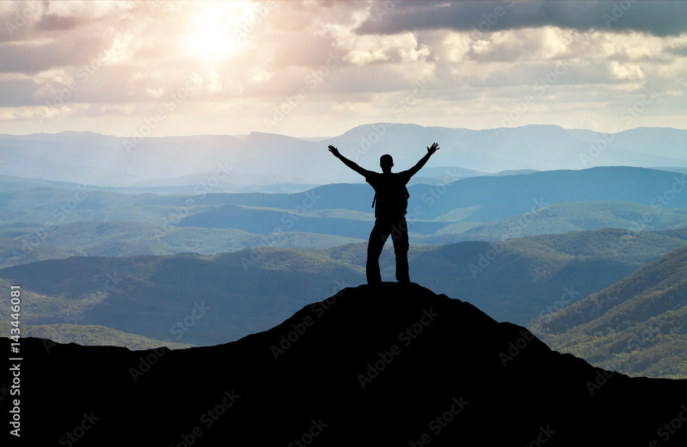 Silhouette of a man on a mountain top. Person on the rock. Sport and active life concept