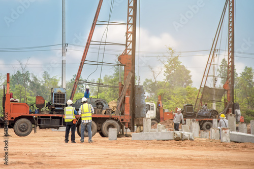 Two engineer inspec construction site pile driving