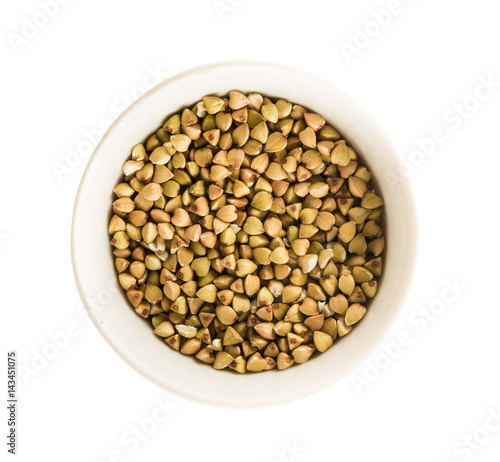 Green buckwheat in a bowl isolated on a white background. Top view.