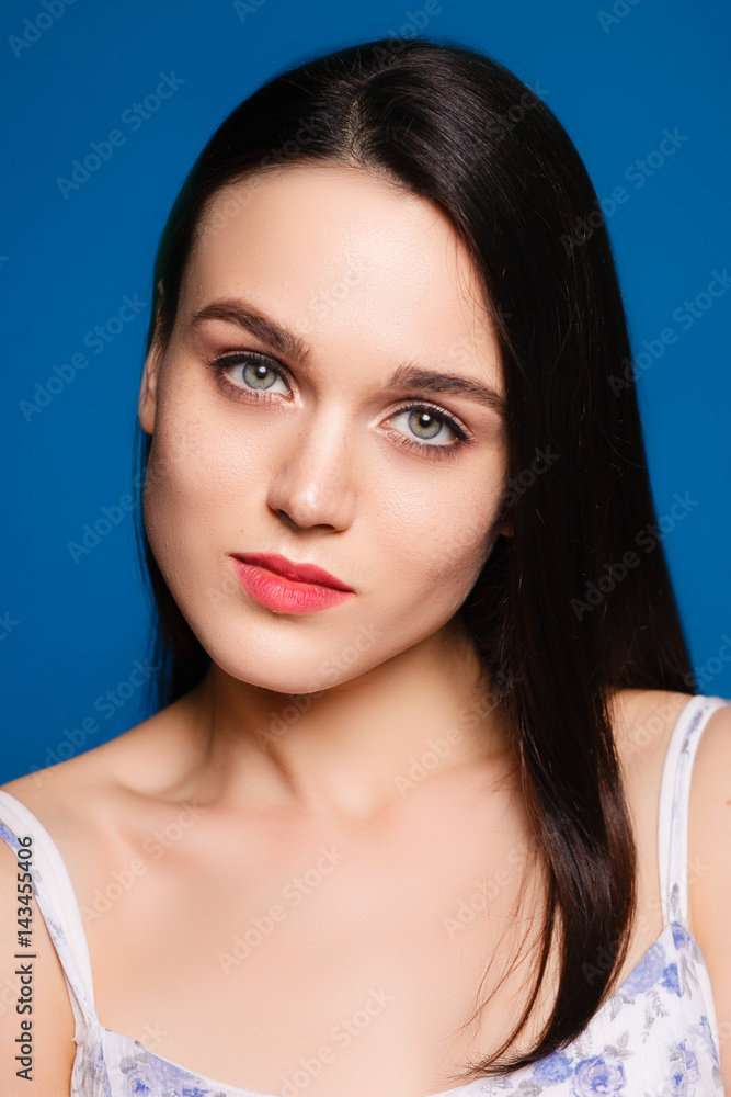 beautiful young brunette woman on a blue background in the studio beautiful young brunette woman on a blue background in the studio