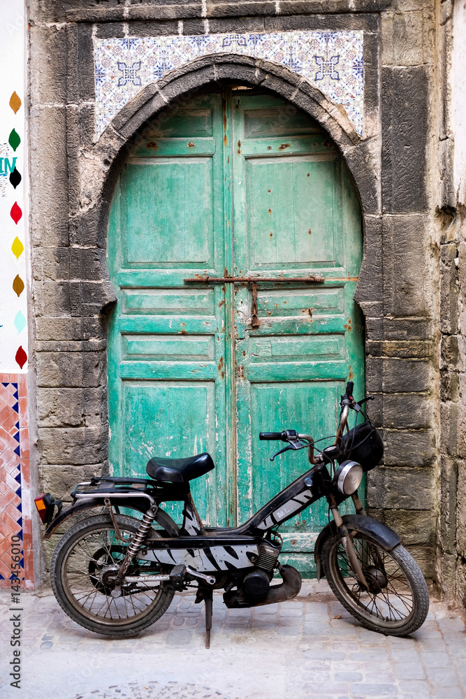 moroccan old door with a bike in the front