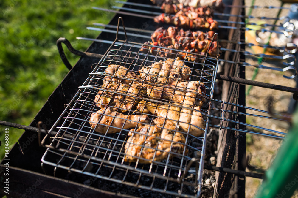 closeup of some meat skewers being grilled in a barbecue. Grilling marinated shashlik on a grill.