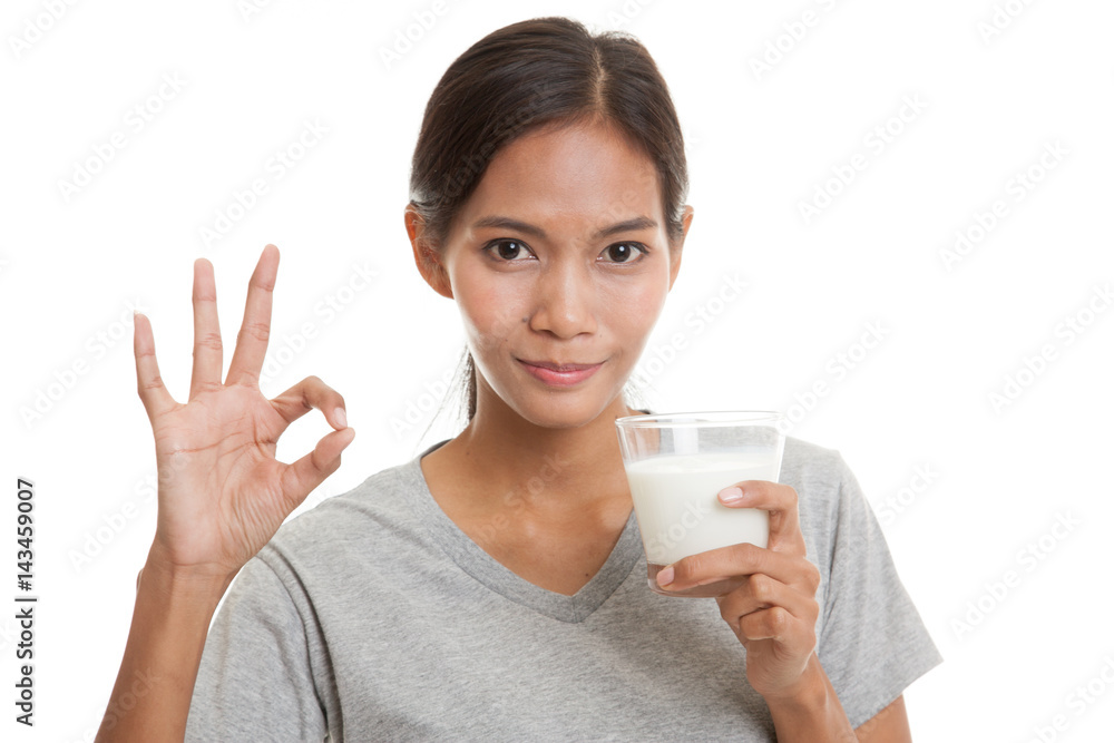 Healthy Asian woman drinking a glass of milk show OK sign. Healthy Asian woman drinking a glass of milk show OK sign.