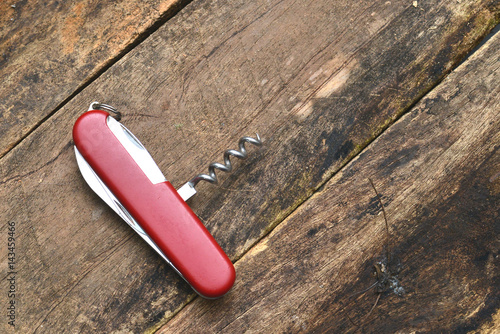Multipurpose knife isolated on wooden background