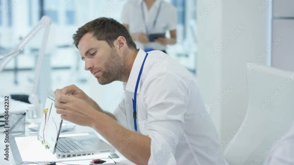 Electronics engineers working in lab building & testing electronic devices Electronics engineers working in lab building & testing electronic devices