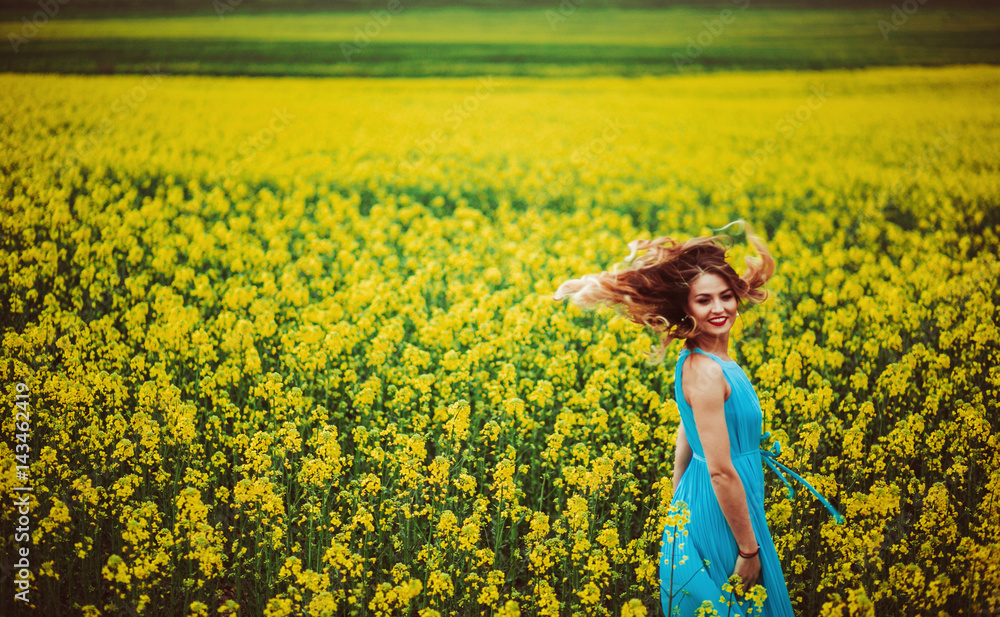 Fototapeta premium The charming girl stands near many flowers