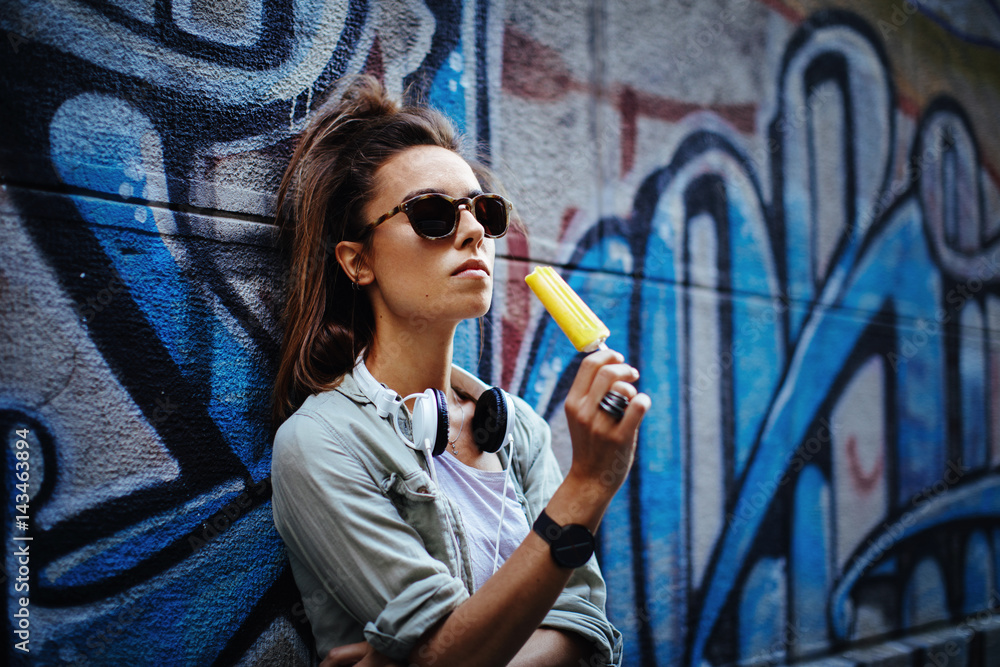 Obraz premium Urban young woman posing against the wall with ice cream