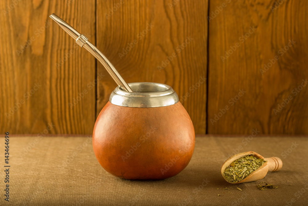 Φωτογραφία Calabash with yerba mate and a wooden spoon against the background of a tree