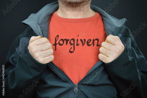 man showing his t-shirt with the word forgiven written on it
