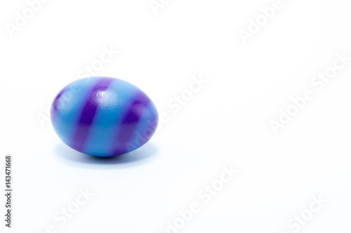 Easter egg hand painted in home - blue with dark blue stripes, isolated in white background