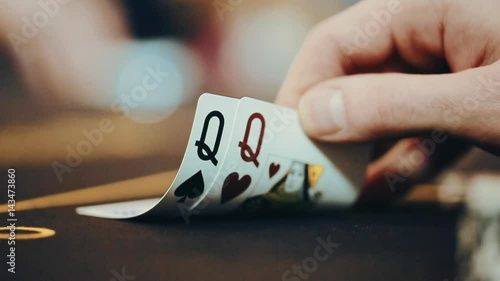 the poker player looks at the cards.