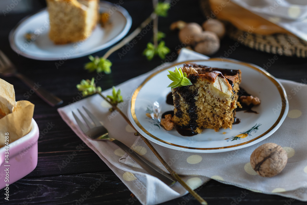 A piece of banana biscuit cake, poured with chocolate and decorated with walnuts and greens. A piece of banana biscuit cake, poured with chocolate and decorated with walnuts and greens.