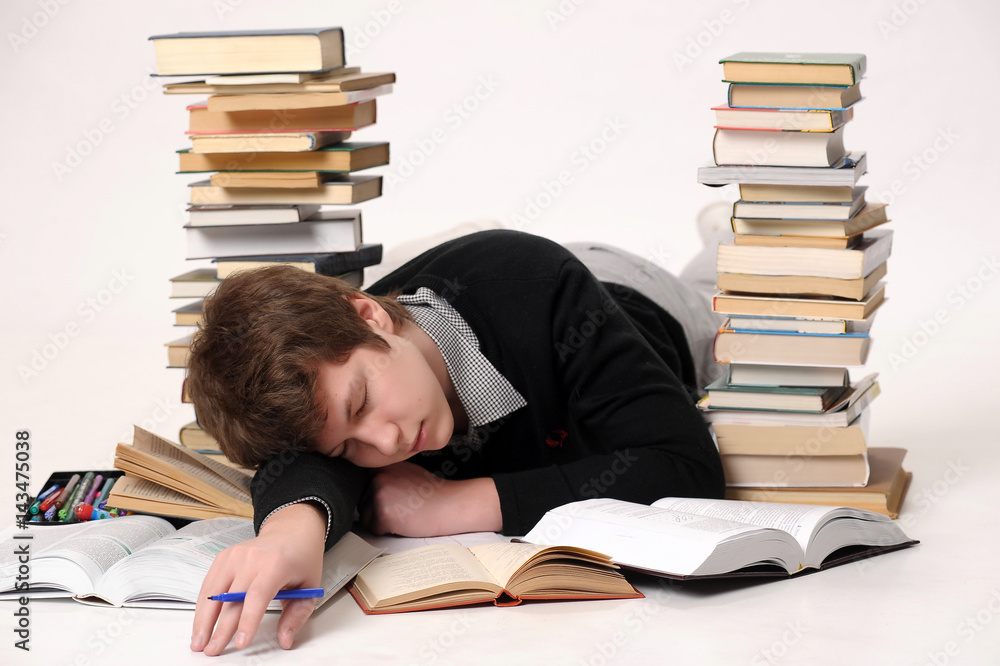 Tired Teenager sleeping on the Books at the Home Tired Teenager sleeping on the Books at the Home