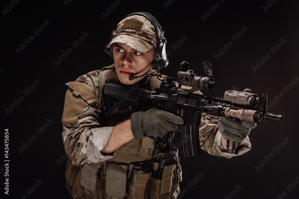 Portrait soldier or private military contractor holding sniper rifle. war, army, weapon, technology and people concept. Image on a black background.