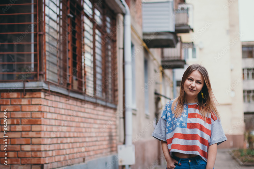 A hipster girl in an old courtyard posing and smiling