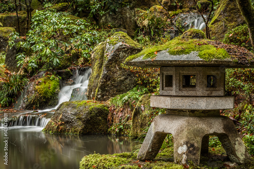 Japanese garden waterfall and statue in the winter