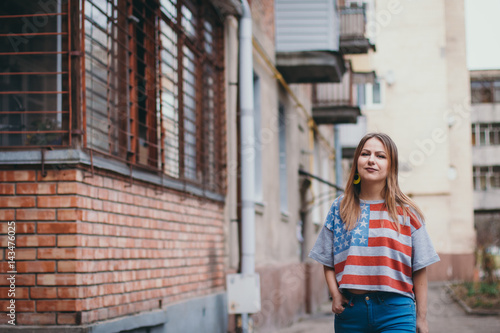 A hipster girl in an old courtyard posing and smiling