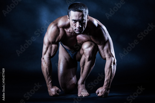 The athlete at the start. Big muscles. A man with large muscles. Body-building. © Grispb