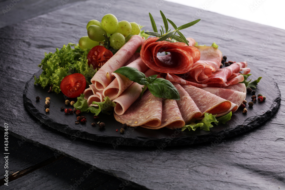 Food tray with delicious salami, pieces of sliced ham, sausage, tomatoes, salad and vegetable - Meat platter with selection Food tray with delicious salami, pieces of sliced ham, sausage, tomatoes, salad and vegetable - Meat platter with selection