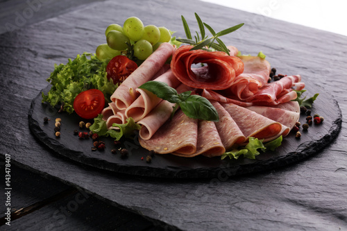 Food tray with delicious salami  pieces of sliced ham  sausage  tomatoes  salad and vegetable - Meat platter with selection