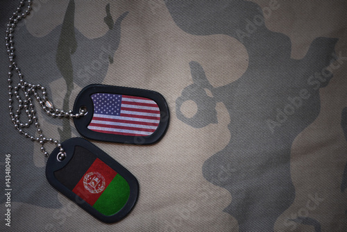 Foto army blank, dog tag with flag of united states of america and afghanistan on the khaki texture background