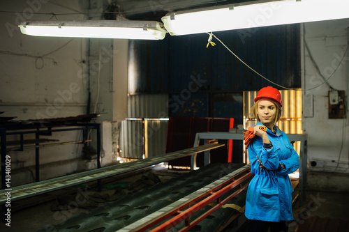 beautiful woman in red safety helmet work as industrial worker