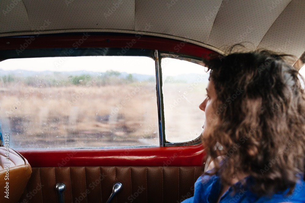 Woman looks out window of vintage car Stock Photo | Adobe Stock