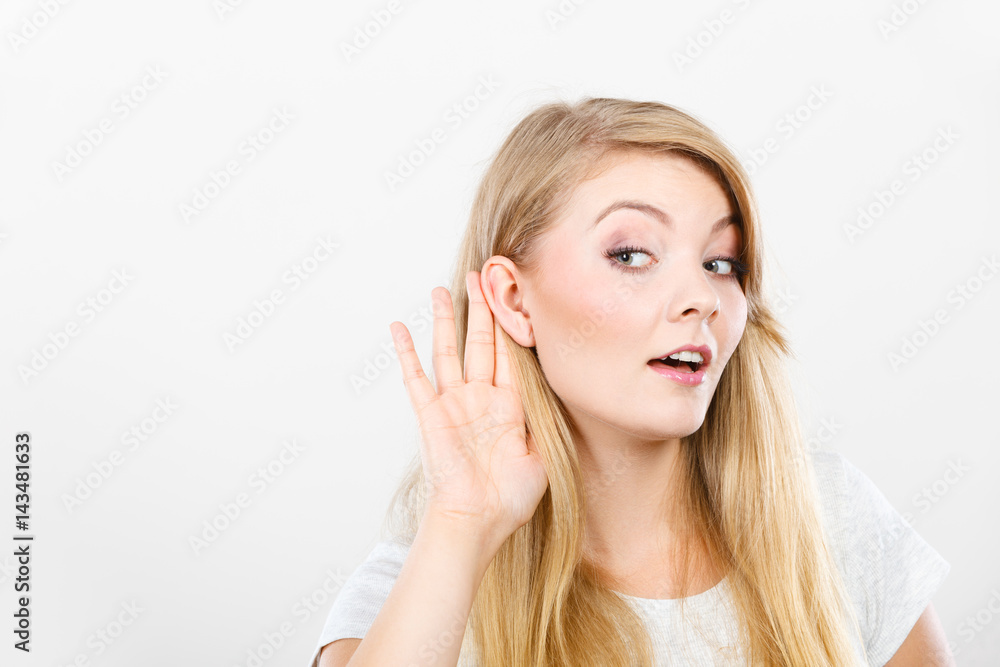 Woman putting hand ear to hear better Woman putting hand ear to hear better