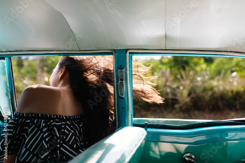 Young woman leaning out of speeding car