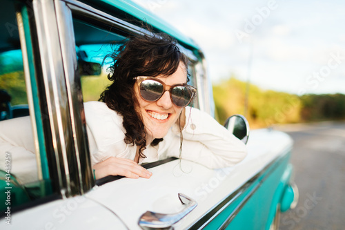 Young woman leaning out of car window