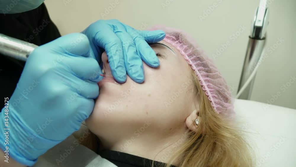 Cosmetologist is making the permanent makeup closeup Cosmetologist is making the permanent makeup closeup