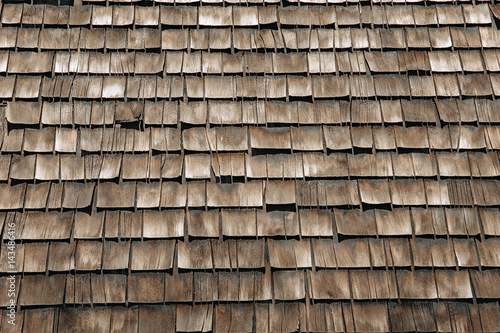weathered wooden shingles on a roof. wooden roof tile of old house photo