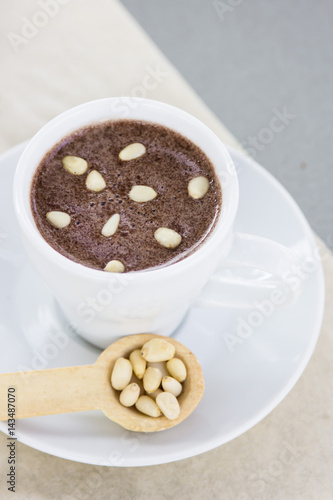 Hot chocolate with pine nuts. Sweet dessert drink in a cafe