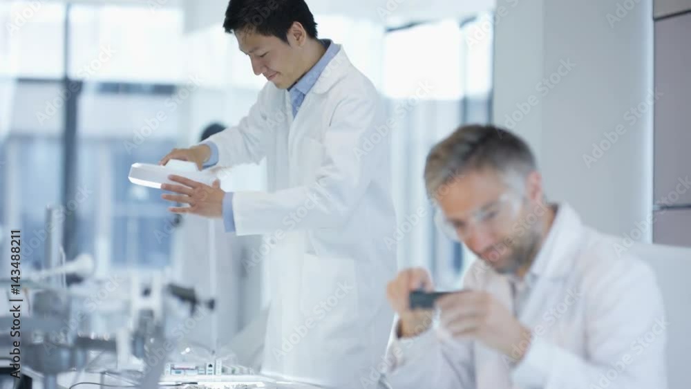 Electronics engineers working in lab building & testing electronic devices Electronics engineers working in lab building & testing electronic devices