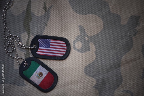Fotografija army blank, dog tag with flag of united states of america and mexico on the khaki texture background