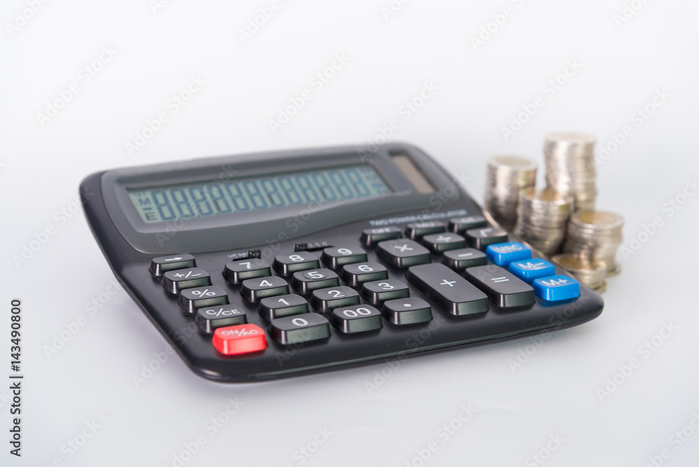 Stack of coins and calculator on white background. Stack of coins and calculator on white background.