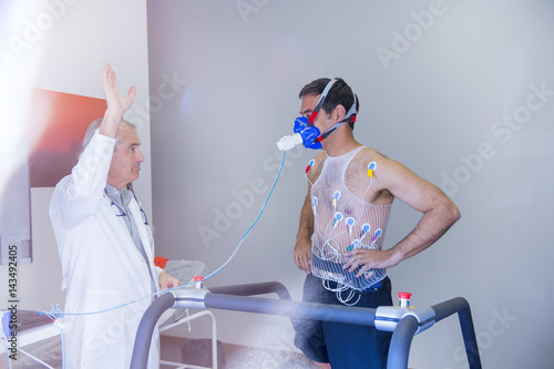 Man doing a stress test of the heart running on a machine photo