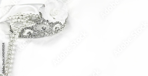 Bridal wedding decorations soft white bride background, silver crown and pearls on satin with space for text