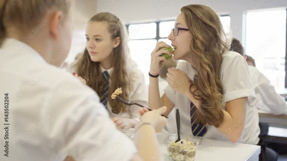 Children in school cafeteria at break time, eating healthy lunches & chatting Children in school cafeteria at break time, eating healthy lunches & chatting