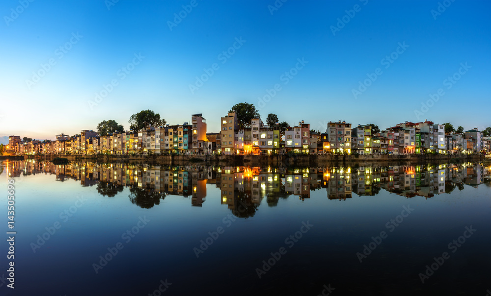 Hanoi cityscape at sunset. Resident buildings by Tien Bien lake, Gia Lam district